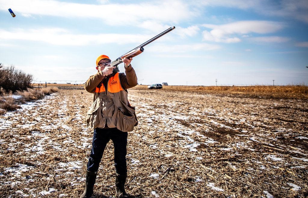 hunter using a semi-automatic shotgun in a field