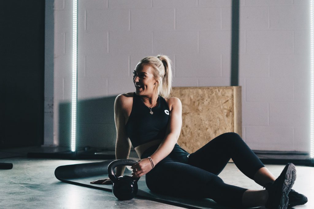 woman in gym with kettlebell resting from explosive exercise