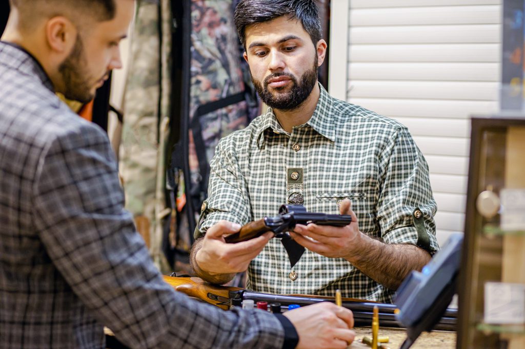 salesman showing customer a revolver