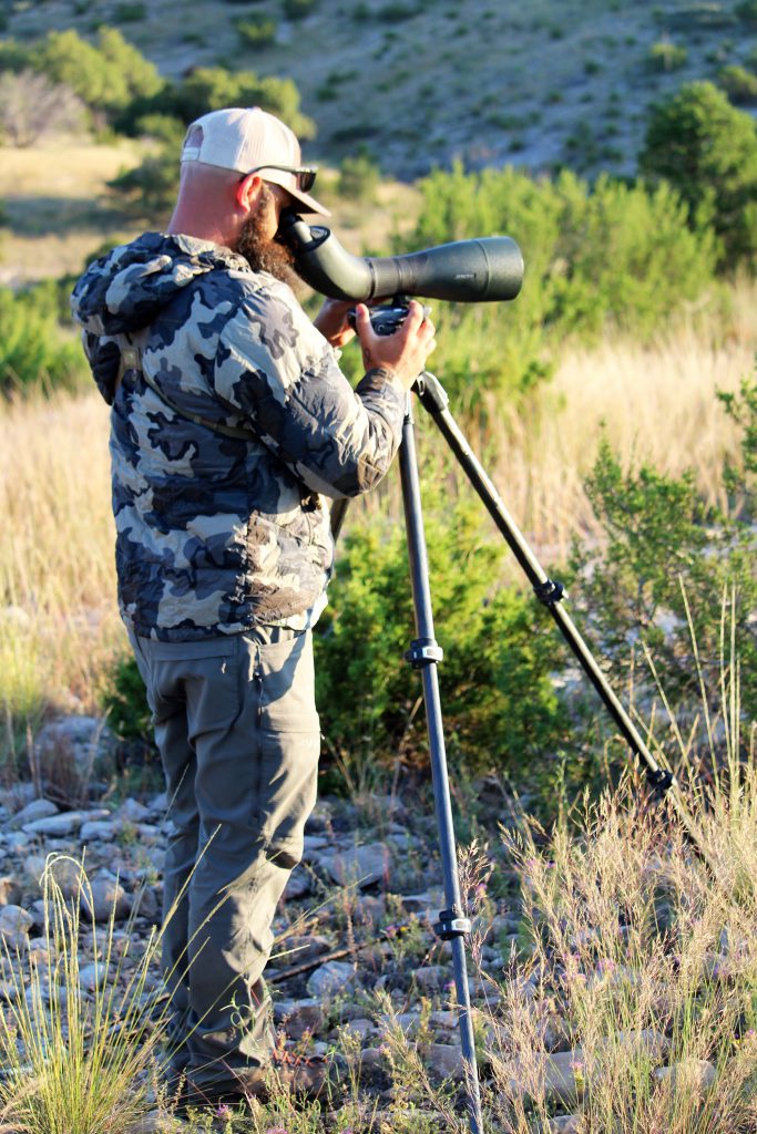 man looking through spotting scope on tripod