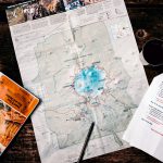 map on table with printed schedule and pen