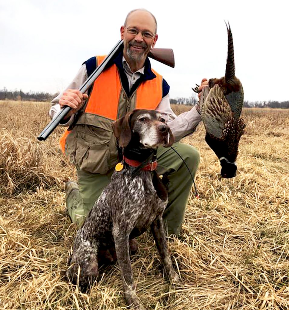 hunter with pheasant and gun dog with side-by-side shotguns