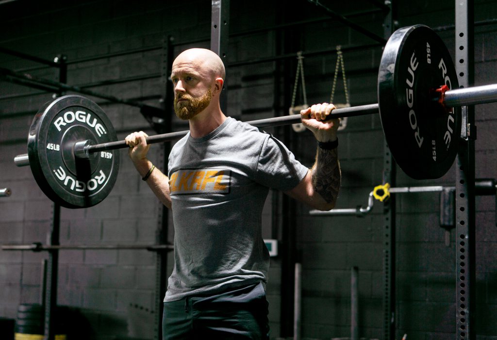 man standing doing squats