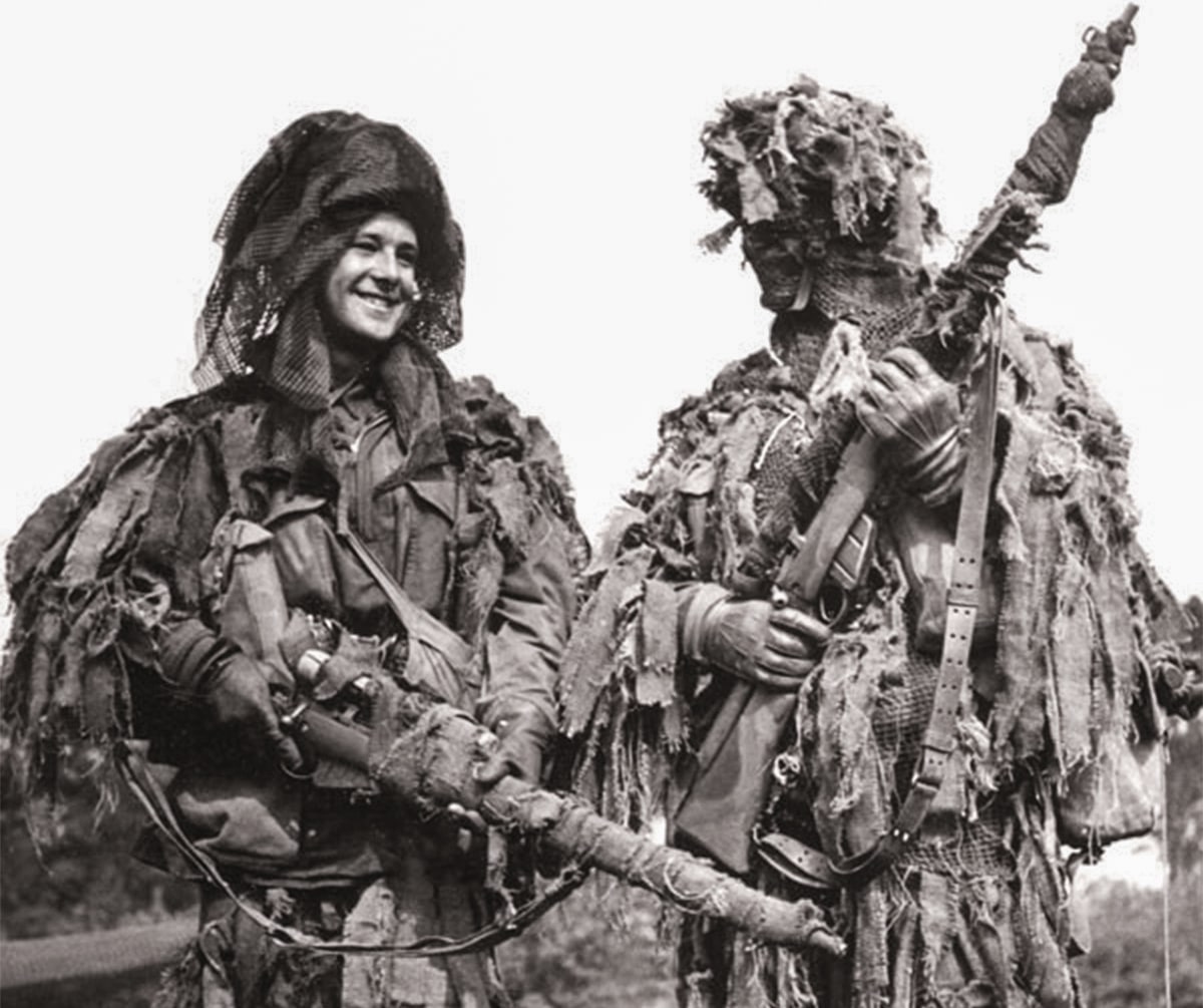 A pair of military snipers display the concealment effects of ghillie suits in the field.