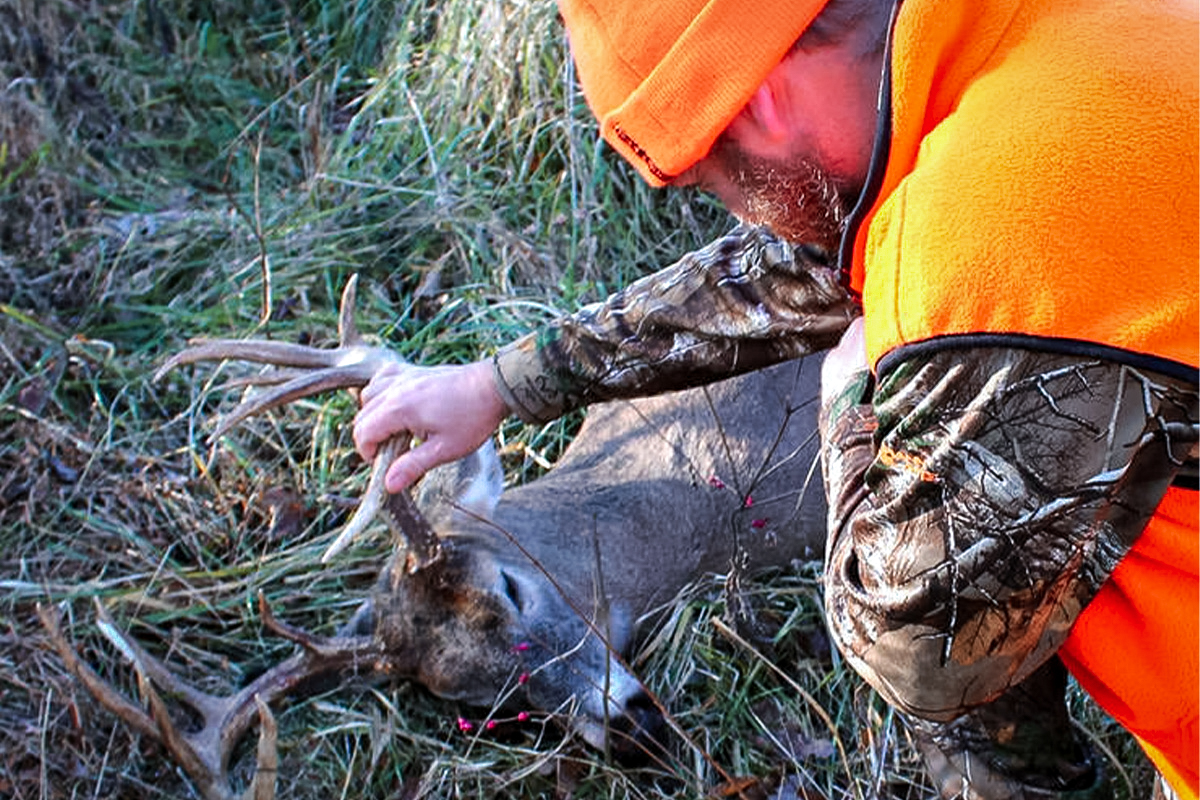 Hunter wearing orange with buck