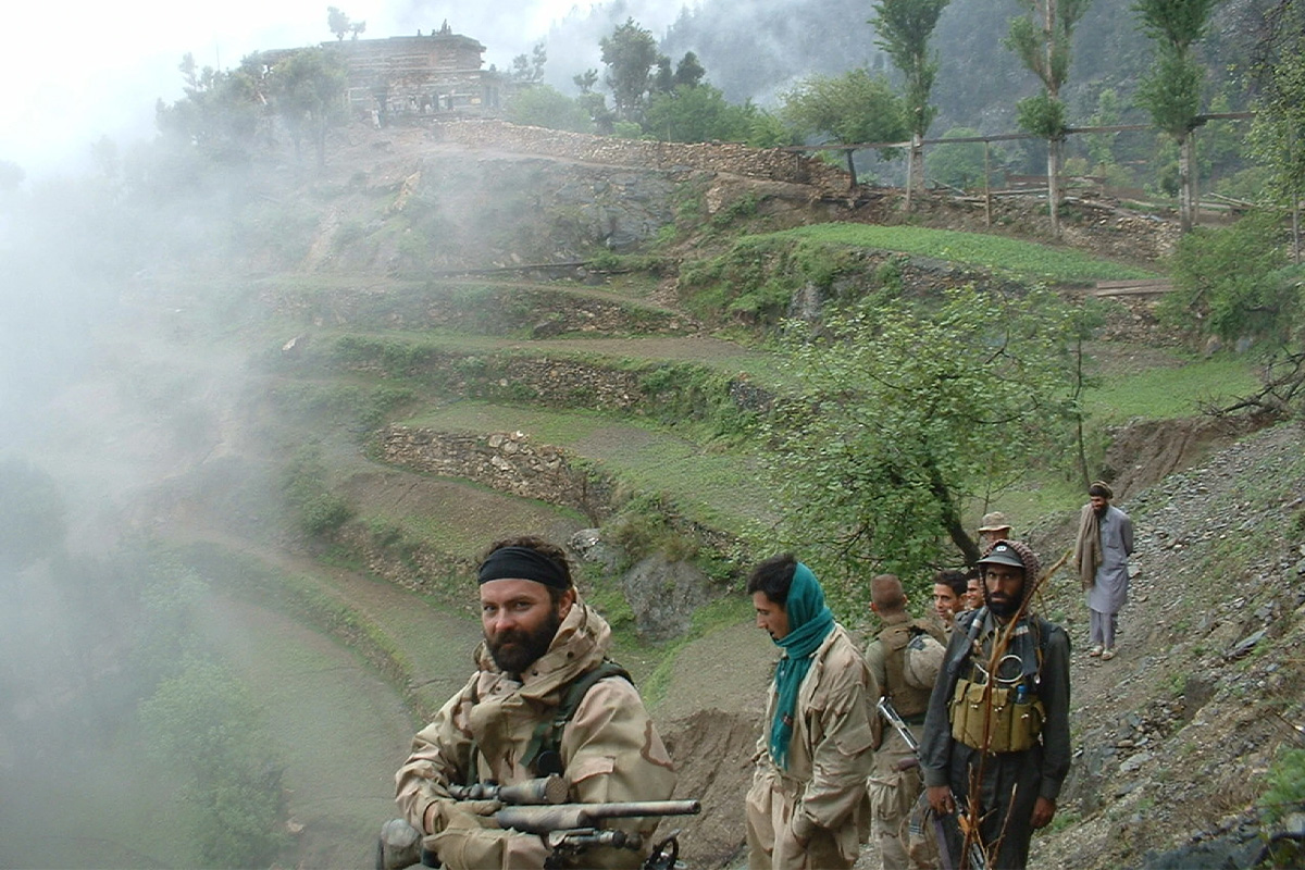 Tyr Symank and his militia force depart a remote mountain village along the Afghanistan-Pakistan border in spring 2004