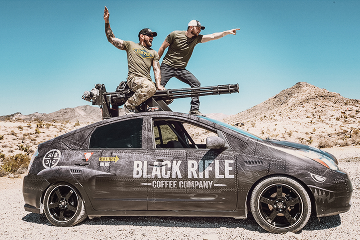 Black Rifle Coffee Company’s Mat Best, left, and Richard Ryan, right, on top of a Prius with a mounted M61 Vulcan cannon.
