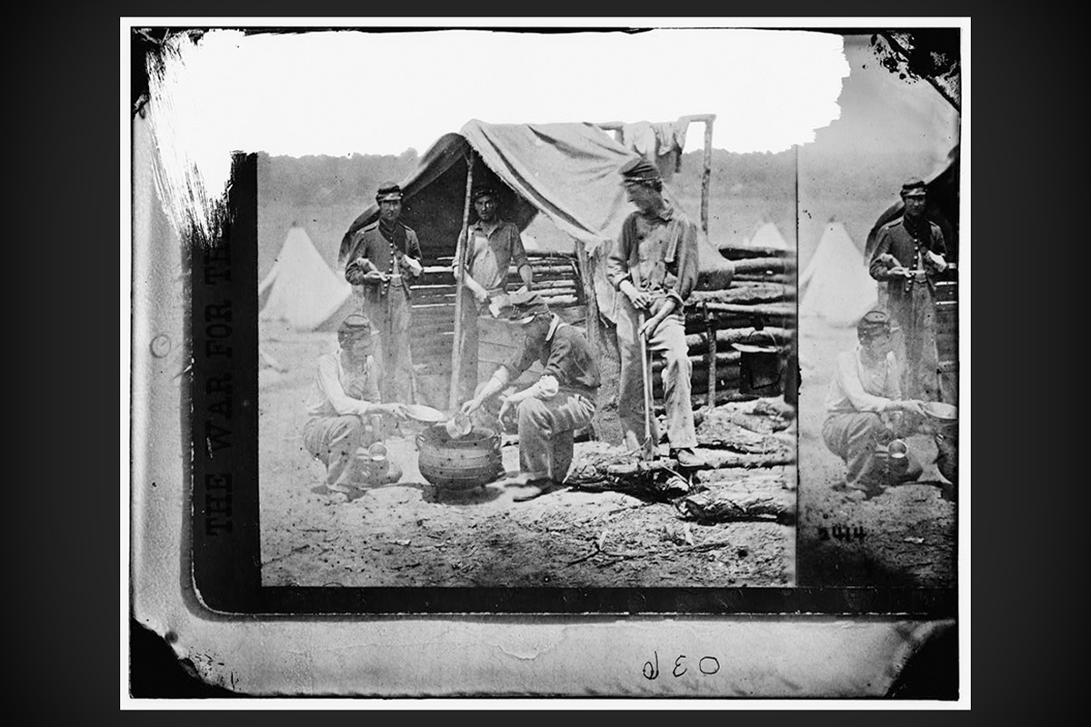 Union soldiers from the 71st New York Volunteers cook over a campfire in 1861.