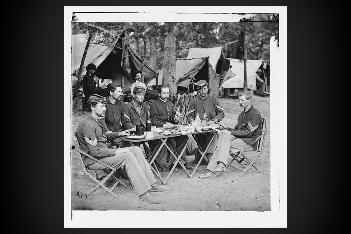 Soldiers from the 93rd New York Infantry eat a meal in 1863.