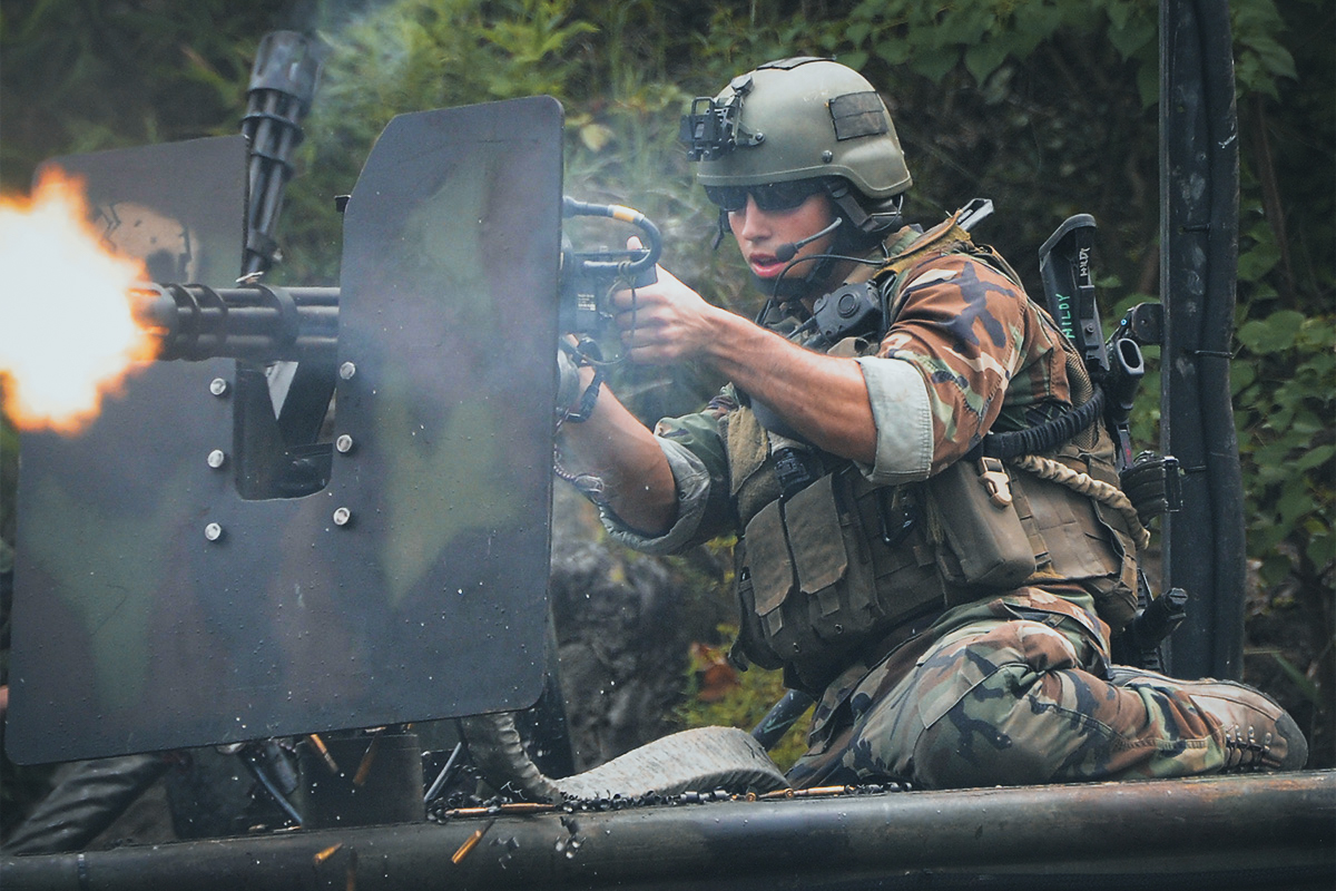 A US Navy Special Warfare combatant-craft crewman on a special operations craft-riverine fires a Minigun at the Stennis Space Center in Mississippi, August 2009.