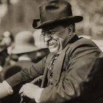 Theodore Roosevelt passing through a crowd smiling