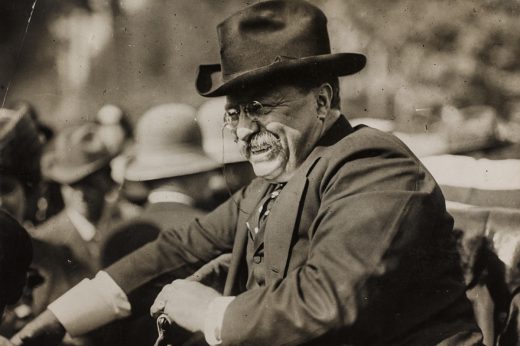 Theodore Roosevelt passing through a crowd smiling