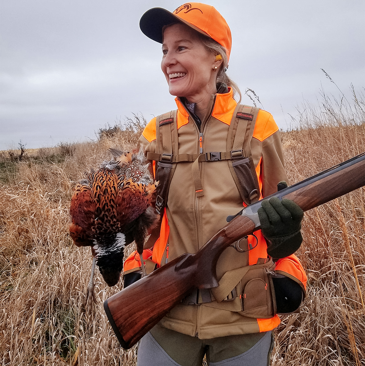 Happy hunter holds a wild pheasant and a 12-gauge, German-made F16 Blaser. The Blaser has a very low profile action, which helps keep the gun’s recoil moving straight back into the shooter’s shoulder, not up into their face. Germany has a long history of making O/U shotguns for hunting and clay target competition.